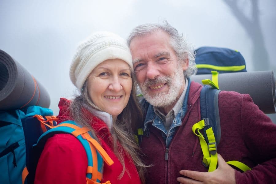 An older couple smiling on a hike
