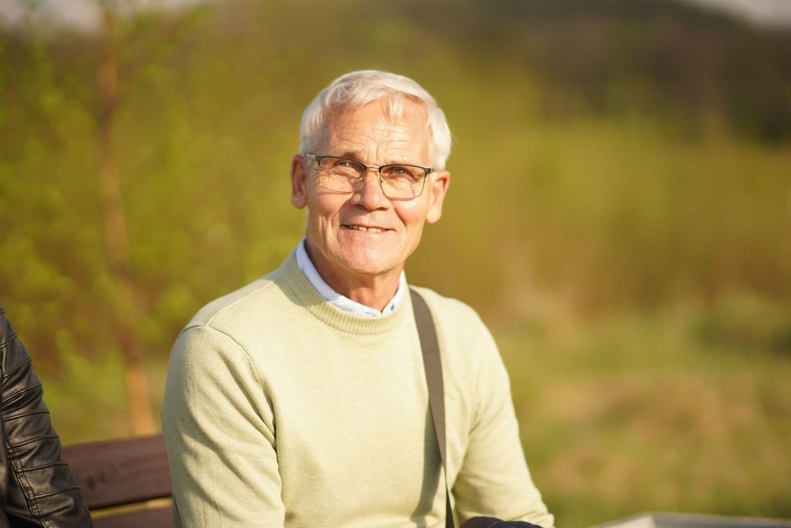 An older man smiling outdoors